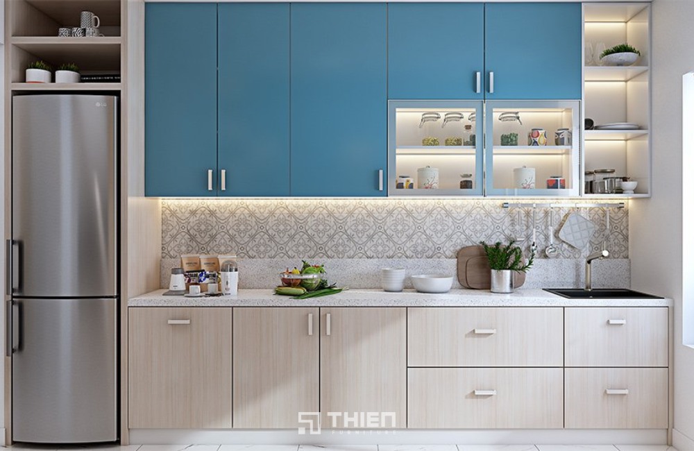 tủ bếp xanh dương pastel, trắng kem vân gỗ và ánh sáng vàng ấm